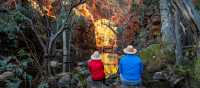 Couple admiring a waterhole along the Larapinta Trail | Lachlan Gardiner