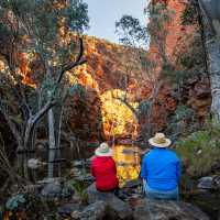 Couple admiring a waterhole along the Larapinta Trail | Lachlan Gardiner